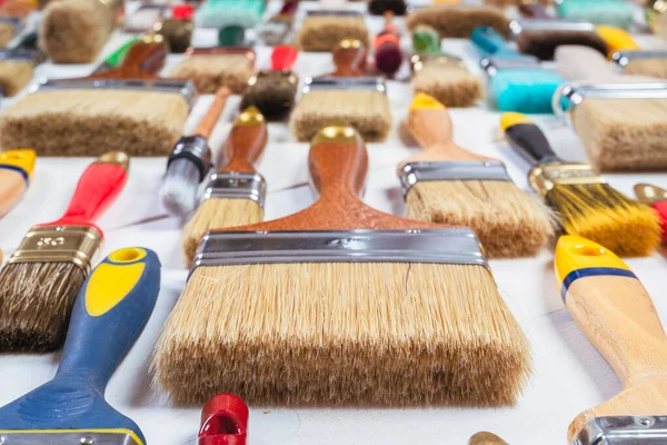 Ahşap masanın üzerinde düz duran boya fırçaları.