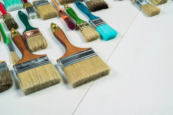 Tahta masadaki boya fırçaları, fotokopi alanı ile düzleştirilmiş.