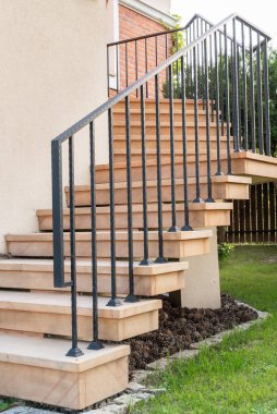 Entrance to the building sandstone staircase step with steel handrail