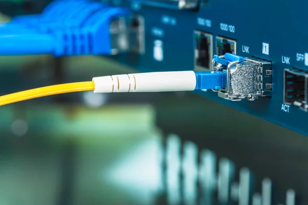 Internet switch in the data center with connected ethernet and fiber optical patch cord cables