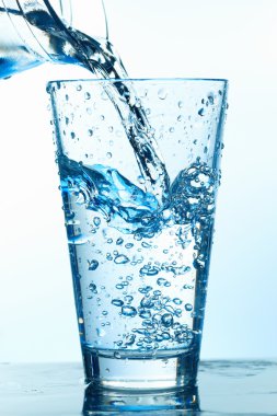 Pouring Water in the Glass With Bubbles. clipart