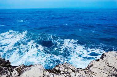Dalgalar taşlı deniz kenarı.