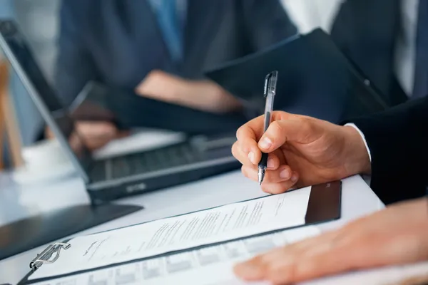 işadamı'nın elleri kalem ve belgeler ile