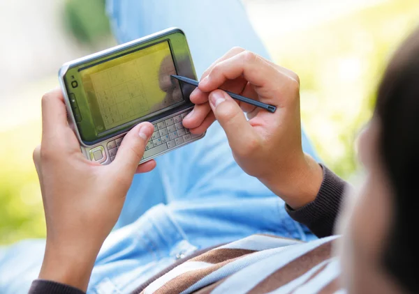 Jovem com seu computador de bolso — Fotografia de Stock