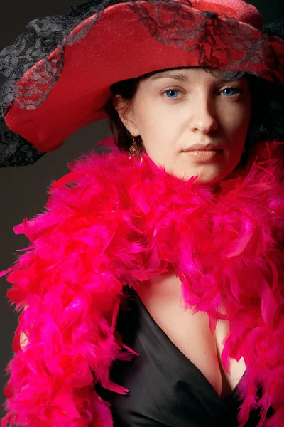 Hermosa mujer en plumas de color rosa y sombrero — Foto de Stock