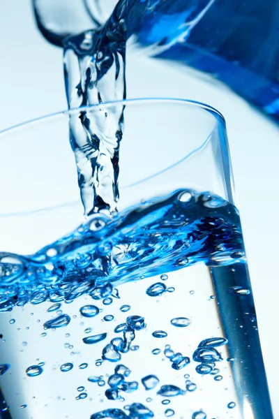 Close-up de uma água de despejo em um copo . — Fotografia de Stock
