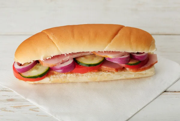 Pequeno sanduíche com carnes e legumes deli em um guardanapo branco — Fotografia de Stock