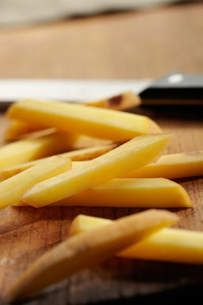 Cortar patatas en una tabla de cortar —  Fotos de Stock