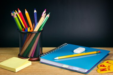 renkli kalem, defter ve diğer ekipmanlar ile öğretmen Masası.