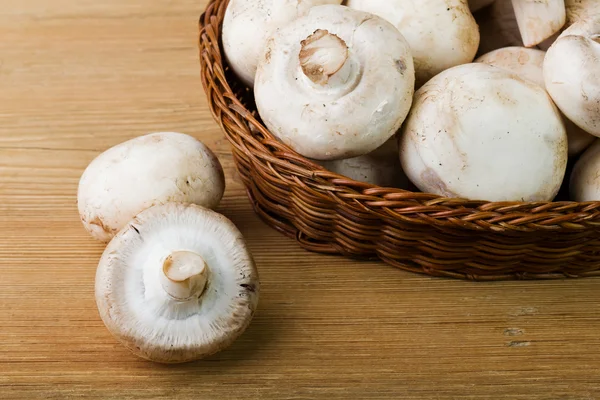 Basket with mushrooms on a wooden background — Stock Photo, Image