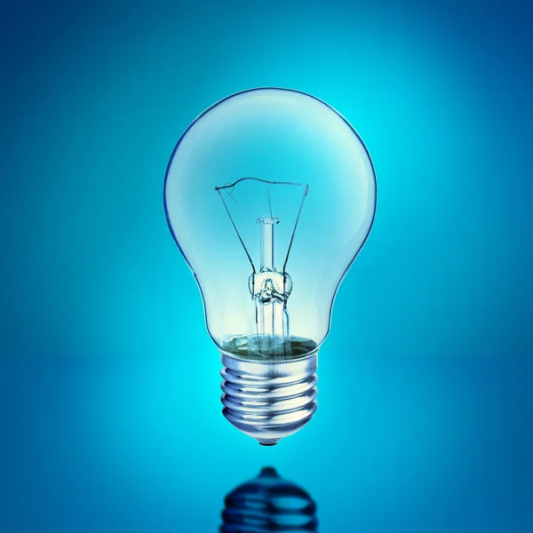 Light bulb on blue background — Stock Photo, Image