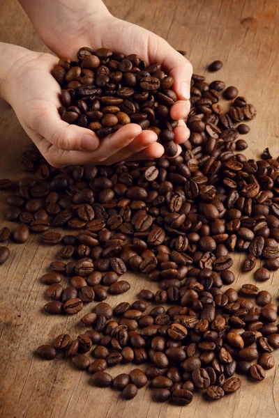 Coffee grains on the hands — Stock Photo, Image