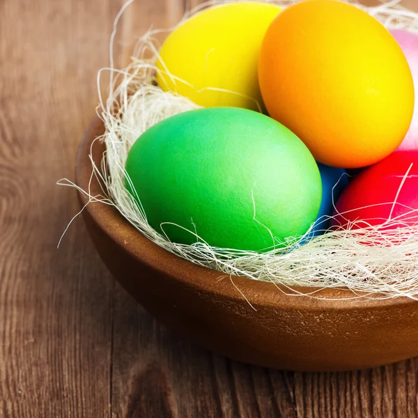 Cesto pasquale con uova di Pasqua su sfondo di legno — Foto Stock