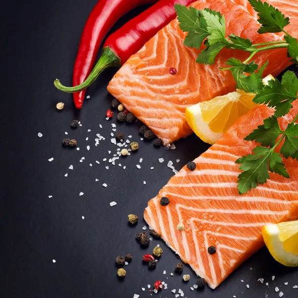 Salmão fresco em prato preto — Fotografia de Stock