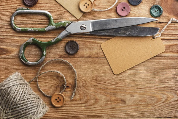 Oude schaar en knoppen op de houten tafel — Stockfoto