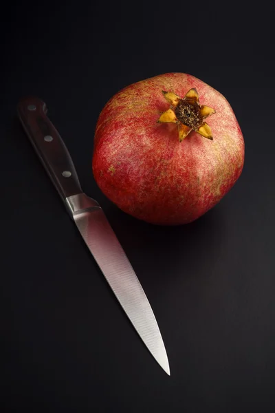 ザクロと黒の背景上にナイフ — ストック写真