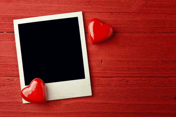 Blank photo and small red hearts — Stock Photo, Image