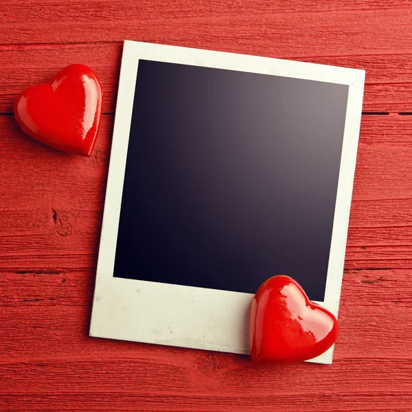 Blank photo and small red hearts — Stock Photo, Image