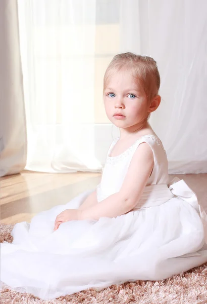 Schönes kleines Mädchen in einem weißen Kleid Stockbild