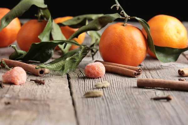 Verse mandarijn sinaasappelen en kaneel op houten tafel — Stockfoto