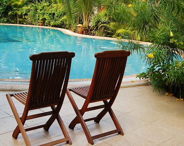 Two wooden chairs at the poolside — Stock Photo, Image