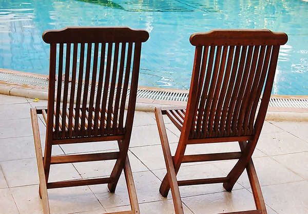 Twee houten stoelen bij het zwembad — Stockfoto