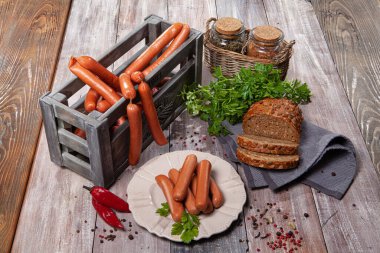 Eski ahşap bir masada sosis, biber ve ekmek. 