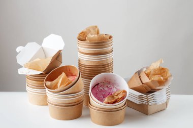 Arka planda kirli, tek kullanımlık kaseler ve kutular var. Sürdürülemez kavram.