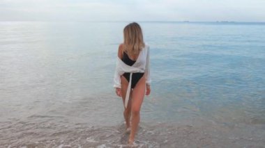 Plajda genç ve çekici bir kadının portresi.