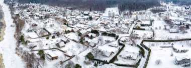 Snow covered village in Baltic sea shore. Areal view from drone