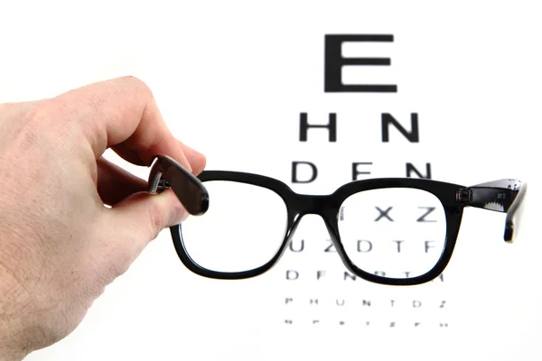 Eye test chart and black glasses — Stock Photo, Image