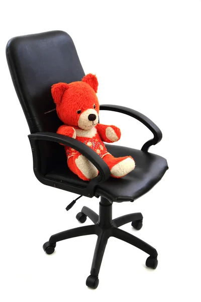 Игрушка красного медведя в офисном кресле — стоковое фото