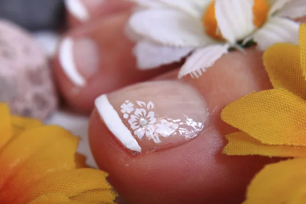Pedicure nagels, voeten en bloemen — Stockfoto