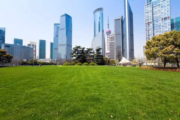 Городской парк с современным строительным фоном в Шанхае — стоковое фото