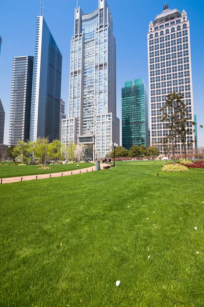 Городской парк с современным строительным фоном в Шанхае — стоковое фото