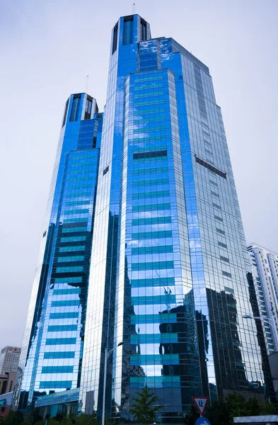 Edifício de vidro Highrise com céu e nuvens de reflexão — Fotografia de Stock