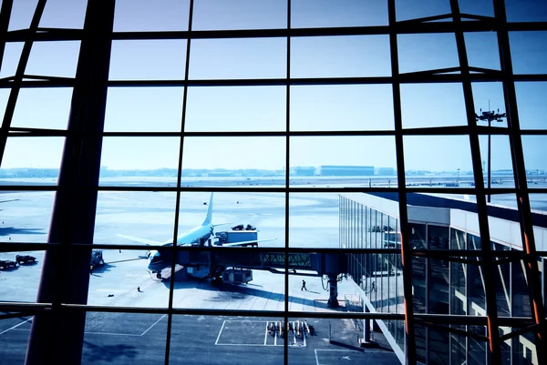 Parked aircraft on an airport through the gate window — Stock Photo, Image