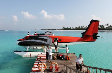 Red seaplane at the docks of an exotic resort in Maldives clipart