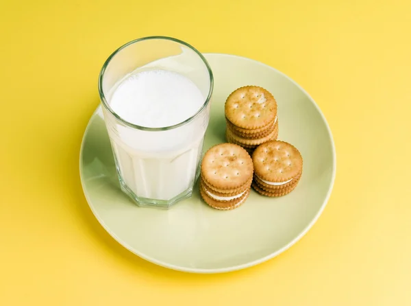 Placa de crema de leche llena de bizcocho y un vaso de leche aislado en el plato —  Fotos de Stock