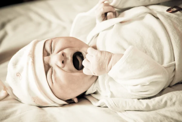 Recém-nascido chorando na cama, foco seletivo — Fotografia de Stock