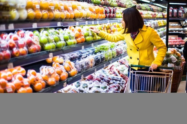 Genç bir kadın süpermarkette alışveriş yapıyor. — Stok fotoğraf