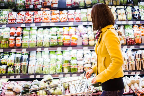 Mujer joven de compras en el supermercado — Foto de Stock