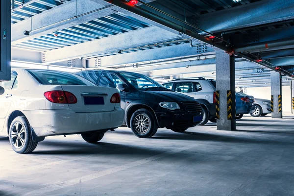 Bazı park edilmiş arabalar ile iç kapalı otopark. — Stok fotoğraf