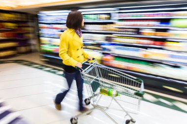 Genç kadın Hareket Bulanıklığı süpermarkette alışveriş