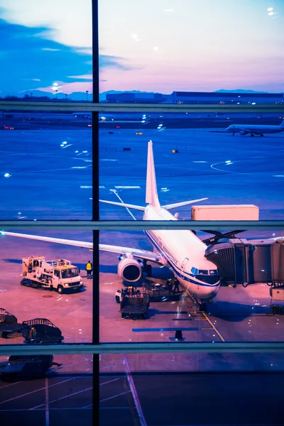 Geparkeerde vliegtuigen op luchthaven van Peking door het raam poort — Stockfoto