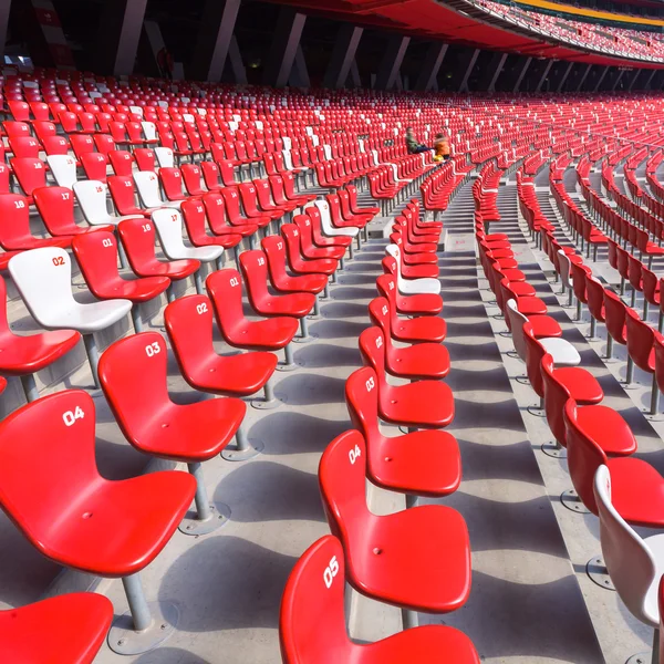 Czerwone krzesła trybuny w duży stadion — Zdjęcie stockowe