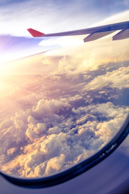 Bulutlar ve gökyüzü bir uçağın penceresinden görüldüğü gibi