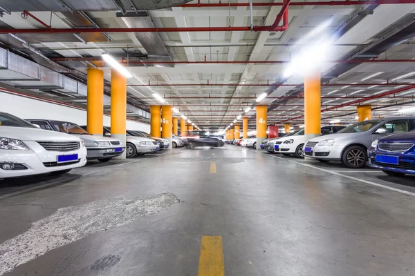 Parcheggio in garage, interno sotterraneo con alcune auto parcheggiate — Foto Stock