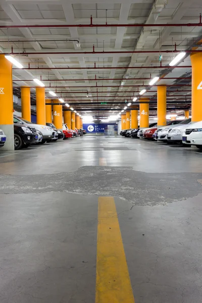 Parcheggio in garage, interno sotterraneo con alcune auto parcheggiate — Foto Stock