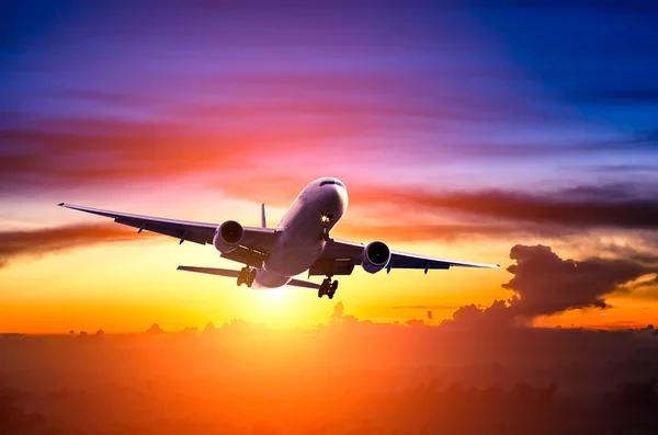 Airplane in the sky at sunrise — Stock Photo, Image